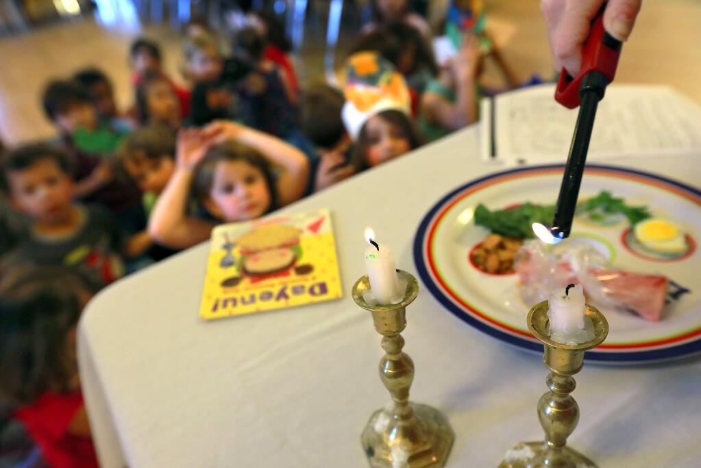Candles are lit at the beginning of a Passover seder for preschool kids at the Gan Israel Preschool in Petaluma on Thursday, March 29, 2018. (Photo by John Burgess/The Press Democrat)