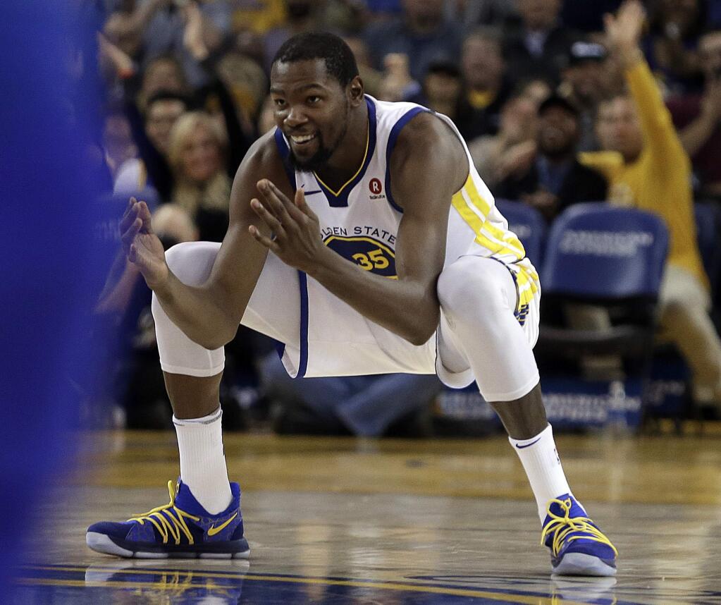 The Golden State Warriors' Kevin Durant celebrates after scoring against the Orlando Magic during the second half ]Monday, Nov. 13, 2017, in Oakland. The Warriors won 110-100. (AP Photo/Ben Margot)
