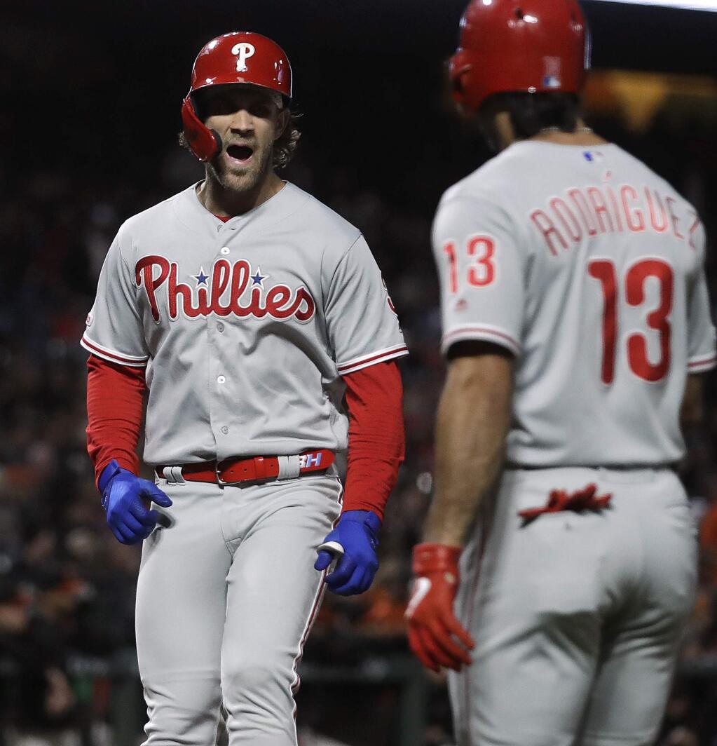 The Philadelphia Phillies' Bryce Harper, left, celebrates with Sean Rodriguez after hitting a three-run home run off the San Francisco Giants' Tony Watson during the seventh inning Friday, Aug. 9, 2019, in San Francisco. (AP Photo/Ben Margot)