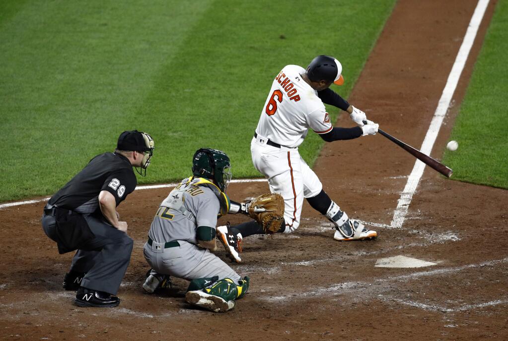 Baltimore Orioles' Jonathan Schoop hits a three-run home run in front of Oakland Athletics catcher Dustin Garneau and home plate umpire Sean Barber in the fifth inning of a baseball game in Baltimore, Monday, Aug. 21, 2017. (AP Photo/Patrick Semansky)