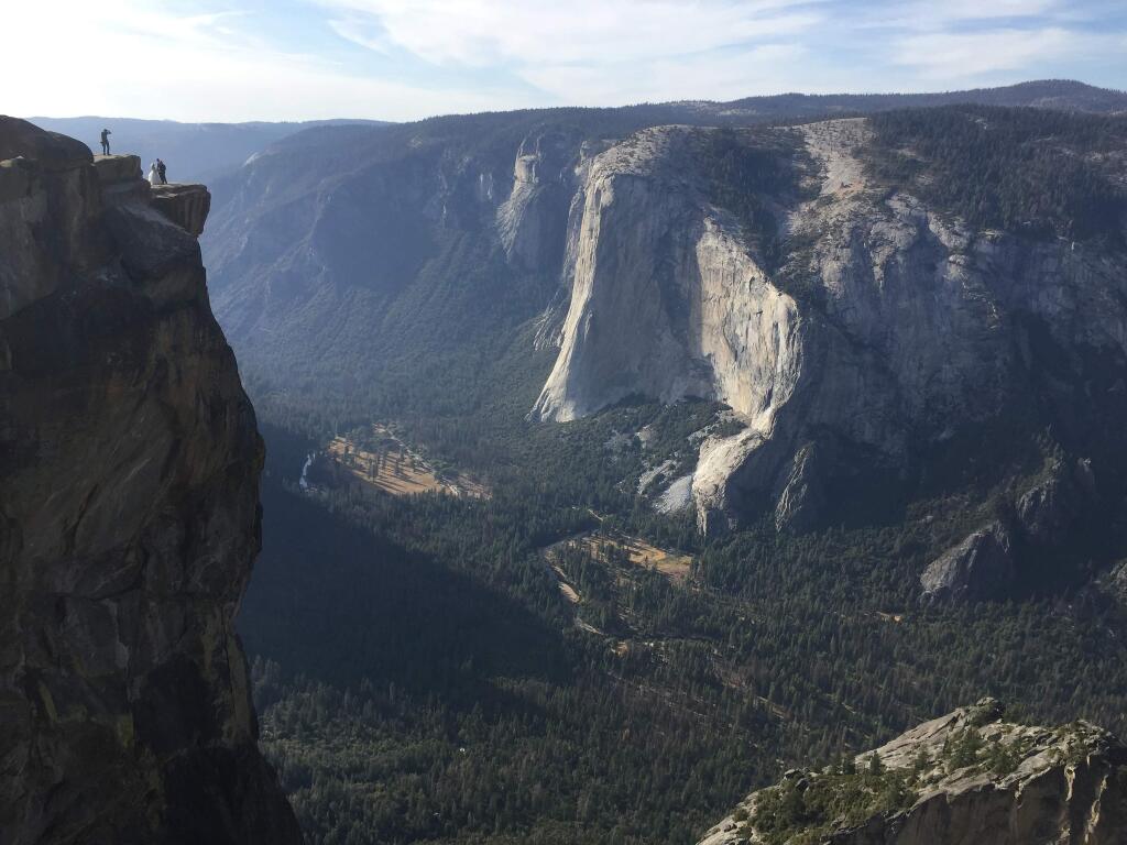 FILE - In this Thursday, Sept. 27, 2018 file photo, an unidentified couple gets married at Taft Point in California's Yosemite National Park. The viewpoint overlooks Yosemite Valley, including El Capitan, a popular vertical ascent for rock climbers across the globe. Yosemite National Park officials have identified two people who died after falling from a popular overlook as a man and a woman from India who were living and working in the United States. Park officials said Monday, Oct. 29, 2018 they were 29-year-old Vishnu Viswanath and his 30-year-old female companion, Meenakshi Moorthy. Park officials recovered their bodies about 800 feet (245 meters) below Taft Point last week. (AP Photo/Amanda Lee Myers, File)