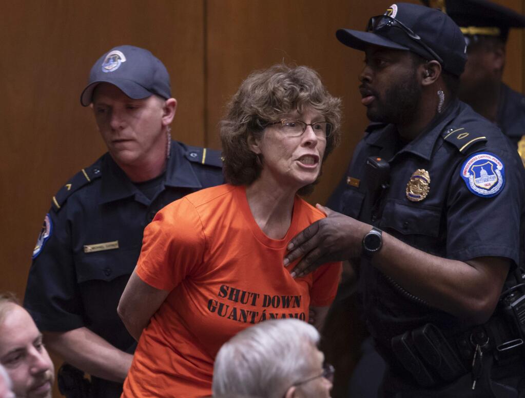 A protester is removed by Capitol Police officers as she shouts at Gina Haspel, President Donald Trump's pick to lead the Central Intelligence Agency, at her confirmation hearing before the Senate Intelligence Committee, on Capitol Hill in Washington, Wednesday, May 9, 2018. (AP Photo/J. Scott Applewhite)