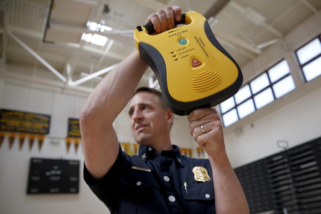 Petaluma Fire Dept. Battalion Chief Jeff Schach shows off an AED, automated external defibrillator, to seventh graders during a CPR training session organized by Save Lives Sonoma at Kenilworth Junior High School on Tuesday, March 31, 2015 in Petaluma, California . (BETH SCHLANKER/ The Press Democrat)