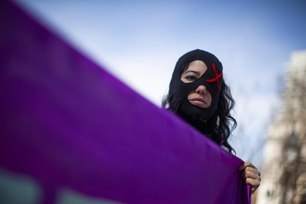 A woman holds as flag as people participate in a rally celebrating International Women's Day at Washington Square Park in New York, Sunday, March 8, 2020. (AP Photo/Eduardo Munoz Alvarez)