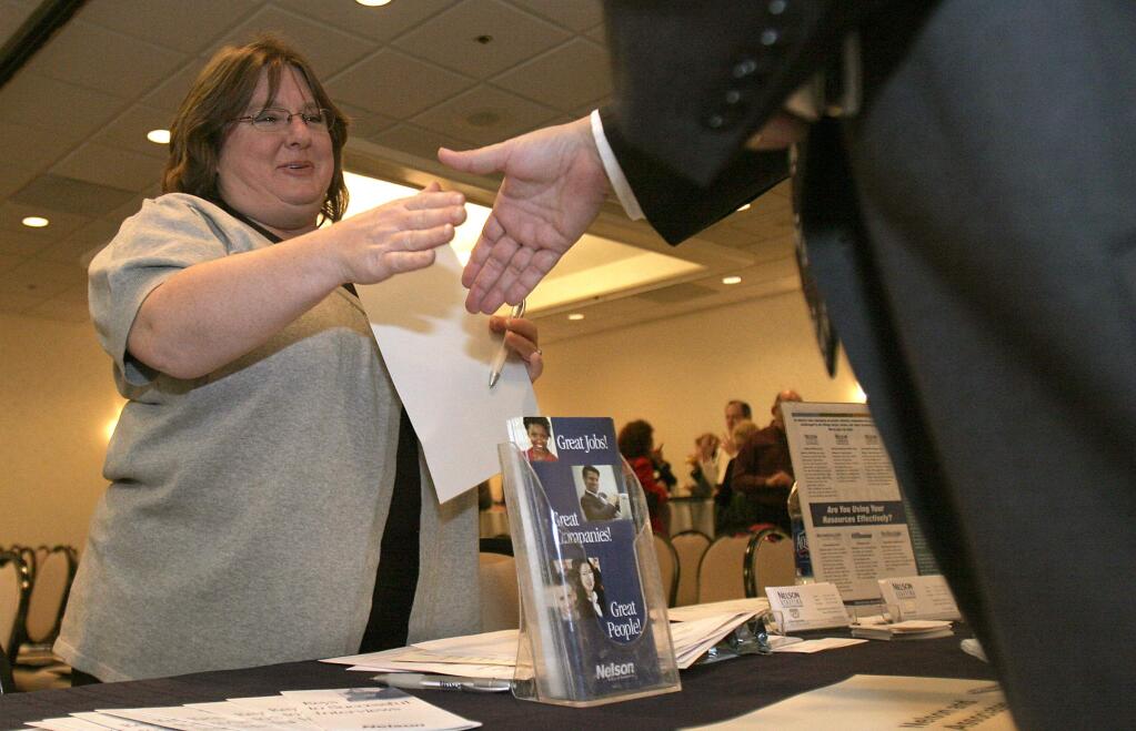 Nelson Staffing's Jennifer Baird talks to an applicant at a job fair at the Hilton Hotel in Santa Rosa in 2010. (PD FILE)