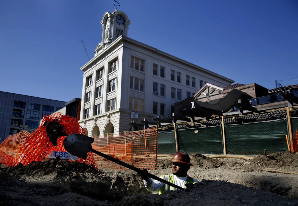 Thompson Builders Corp employee Ruben Corona works to dig a trench around an old gas main at Old Courthouse Square near the Empire Building in Santa Rosa, on Thursday, June 30, 2016. (BETH SCHLANKER/ The Press Democrat)