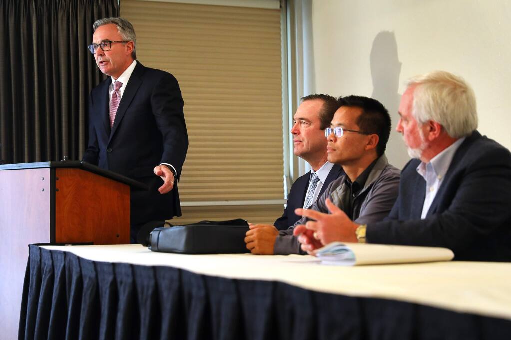Attorney Greg Bentley, of Bentley & More, LLP, left, addresses the media during a press conference announcing a lawsuit by a group of fire victims against AAA for systematically underinsuring their homes and leaving them short of rebuilding costs, while attorney Christopher Kreeger, and plaintiffs Matt Quan and Larry Spanier listen, in Santa Rosa on Tuesday, December 18, 2018. (Christopher Chung/ The Press Democrat)