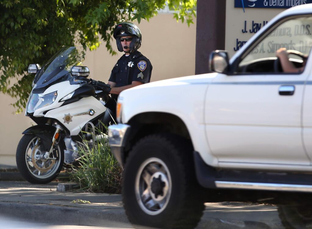 Santa Rosa police Sgt. Mike Numainville watches as cars go by looking for distracted drivers along Mendocino Ave., Friday, April 17, 2015. (CRISTA JEREMIASON / The Press Democrat)
