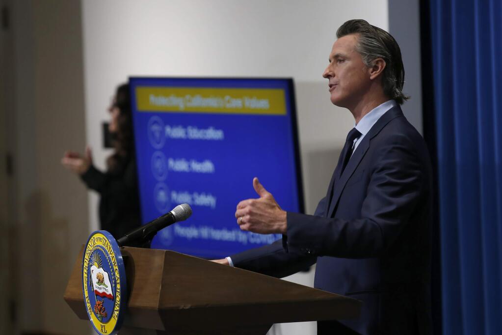 California Gov. Gavin Newsom discusses his revised 2020-2021 state budget during a news conference in Sacramento, Calif., Thursday, May 14, 2020. Reflecting the drastic financial shortfall California is facing from the coronavirus pandemic, Newsom proposed canceling $6.1 billion in spending increases that include nixing planned expansions of health coverage for vulnerable populations. (AP Photo/Rich Pedroncelli, Pool)