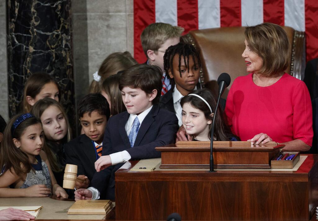 Children test the gavel as they gather around House Speaker-elect Nancy Pelosi of California before she takes the oath at the U.S. Capitol in Washington, Thursday, Jan. 3, 2019. (AP Photo/Carolyn Kaster)