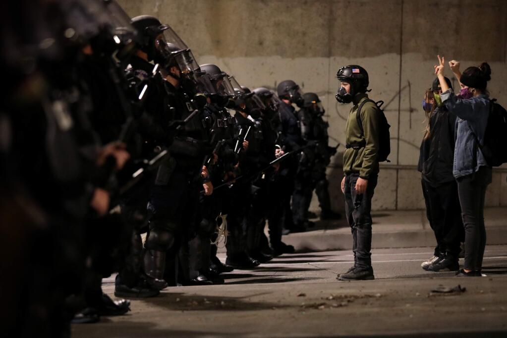 Protesters face off against a line of police officers on Third Street in Santa Rosa, California, on Sunday, May 31, 2020. (Beth Schlanker / The Press Democrat)