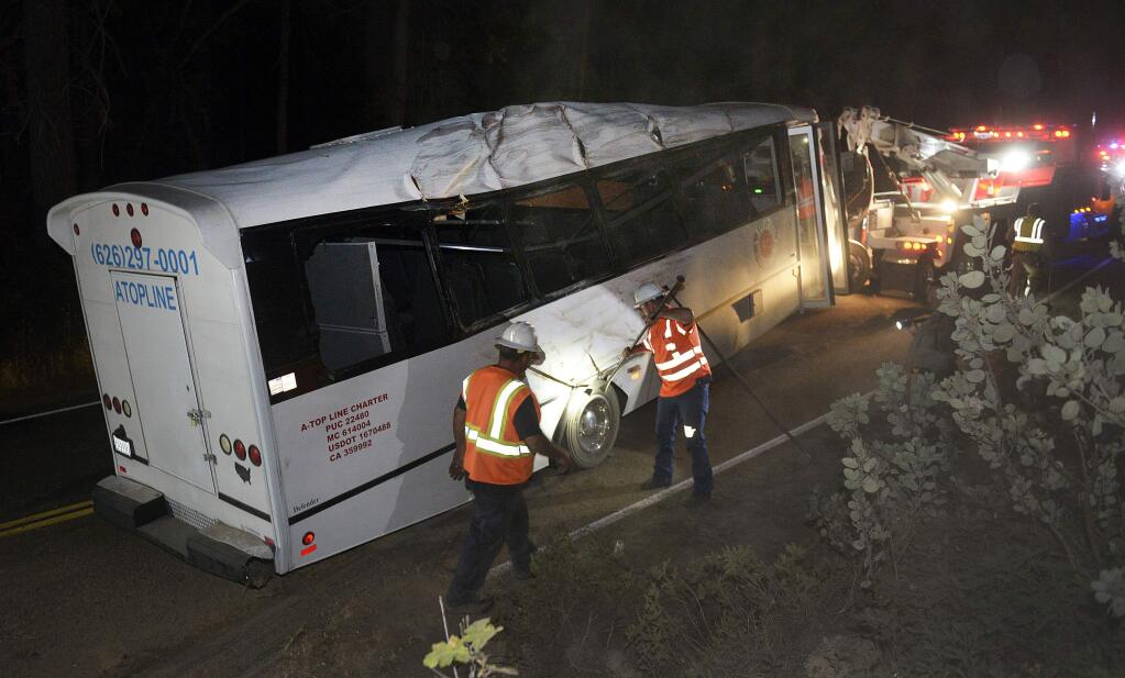 In this Sept, 24, 2016 photo, rescuers work the scene of an accident after a tour bus carrying students from China hit a tree near Yosemite National Park outside the Sierra Nevada town of Oakhurst, Calif. The California Highway Patrol said Sunday at least one passenger was killed and 11 were injured in the accident, the Fresno Bee reports. (Craig Kohlruss/The Fresno Bee via AP)