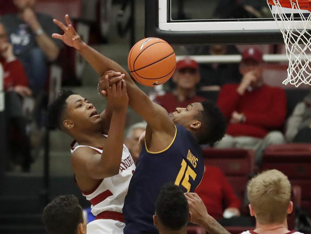 Stanford forward Kezie Okpala, left, is fouled by Cal forward Roman Davis (15) as he drives to the basket with the ball against Cal during the second half aturday, Dec. 30, 2017, in Stanford. (AP Photo/Tony Avelar)