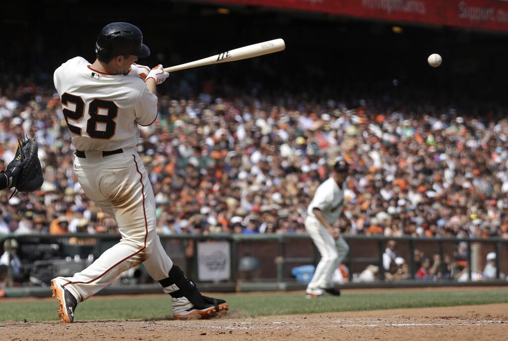 San Francisco Giants' Buster Posey (28) hits a single to score Angel Pagan during the seventh inning of a baseball game against the Chicago White Sox in San Francisco, Wednesday, Aug. 13, 2014. (AP Photo/Jeff Chiu)