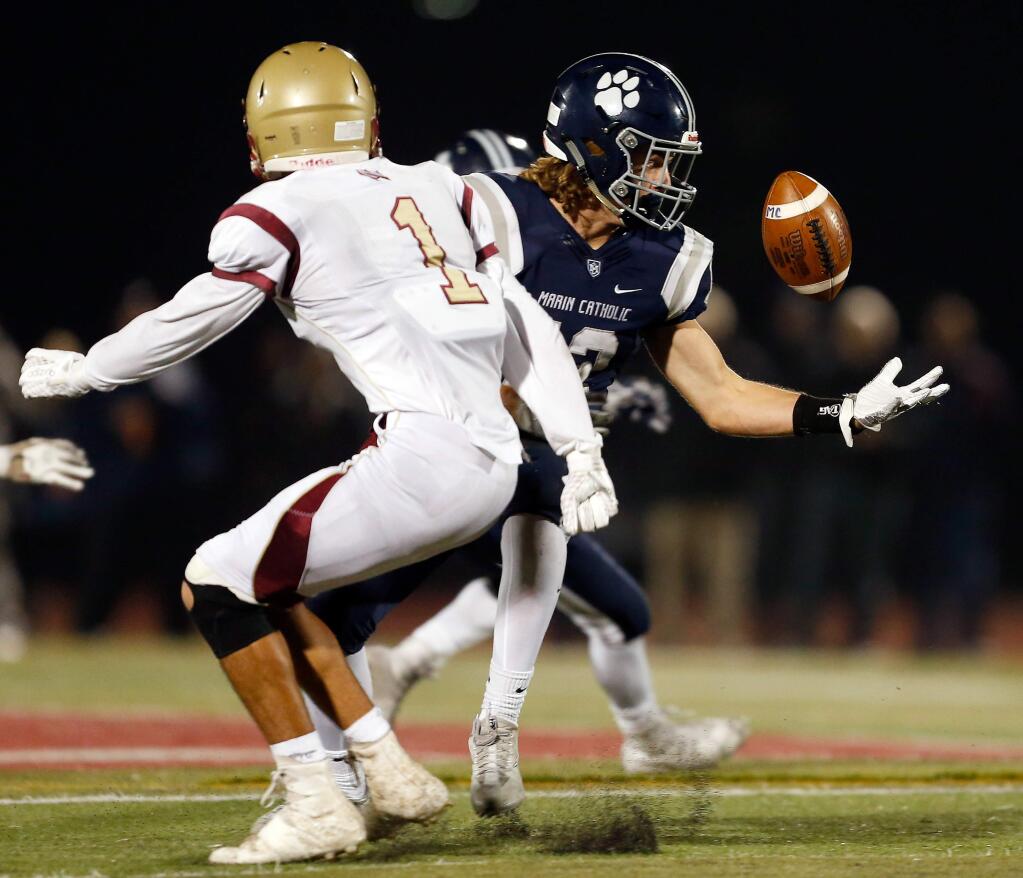 Marin Catholic receiver Peter Brown (12), right, manages to grab the ball for a completed pass after it was tipped and nearly intercepted by Cardinal Newman's Chauncey Leberthon (1) during the first half of the NCS Division 3 varsity football championship game between Cardinal Newman and Marin Catholic high schools in Rohnert Park, California on Saturday, December 2, 2017. (Alvin Jornada / The Press Democrat)