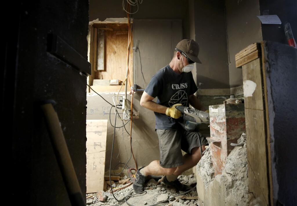 Rico Cividanes chisels out an old safe that was found encased in concrete as workers were installing a DJ booth for KGGV-LP radio inside the recently renovated River Theater in Guerneville on Thursday, July 18, 2019. (BETH SCHLANKER/ The Press Democrat)