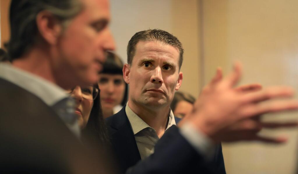 In Middletown, state Sen. Mike McGuire listens as California Gov. Gavin Newsom, Friday, March 22, 2019, announces a plan to help protect California's most wildfire-vulnerable areas. (Kent Porter / The Press Democrat, 2019)