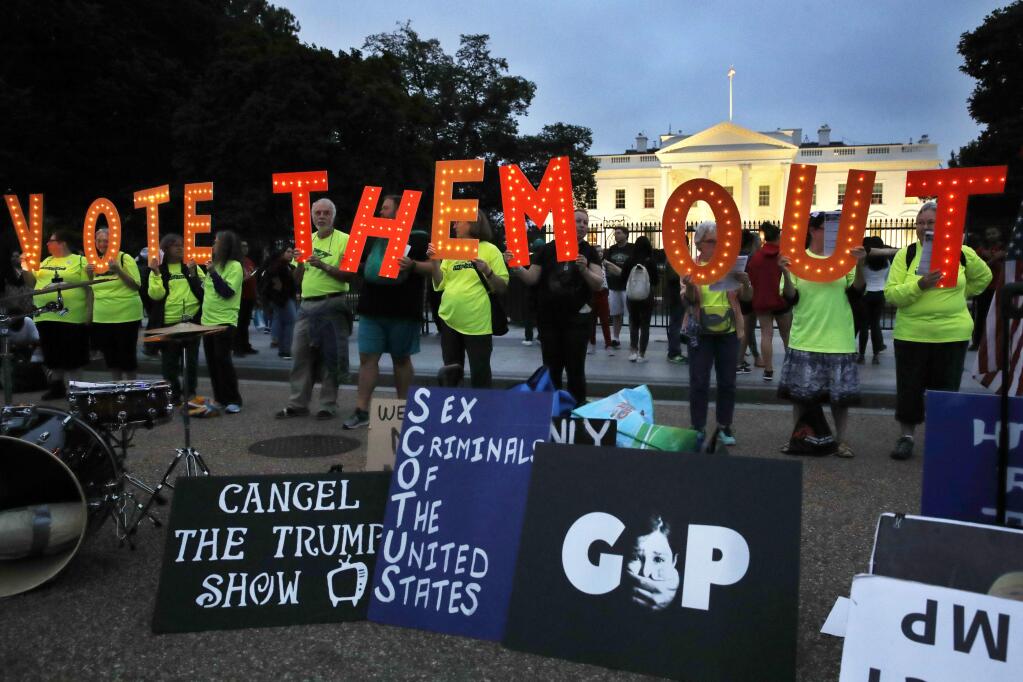 People with the group Herndon Reston Indivisible hold up letters spelling 'VOTE THEM OUT' during a demonstration outside the White House on Oct. 6. (JACQUELYN MARTIN / Associated Press)