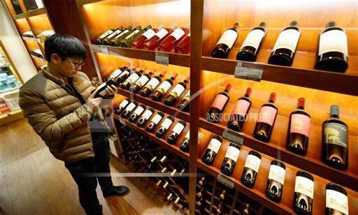 A Chinese employee checks a bottle of wine at a bonded logistics center in Zouping county, Binzhou city, east China's Shandong province in January 2015. (IMAGINECHINA VIA AP)