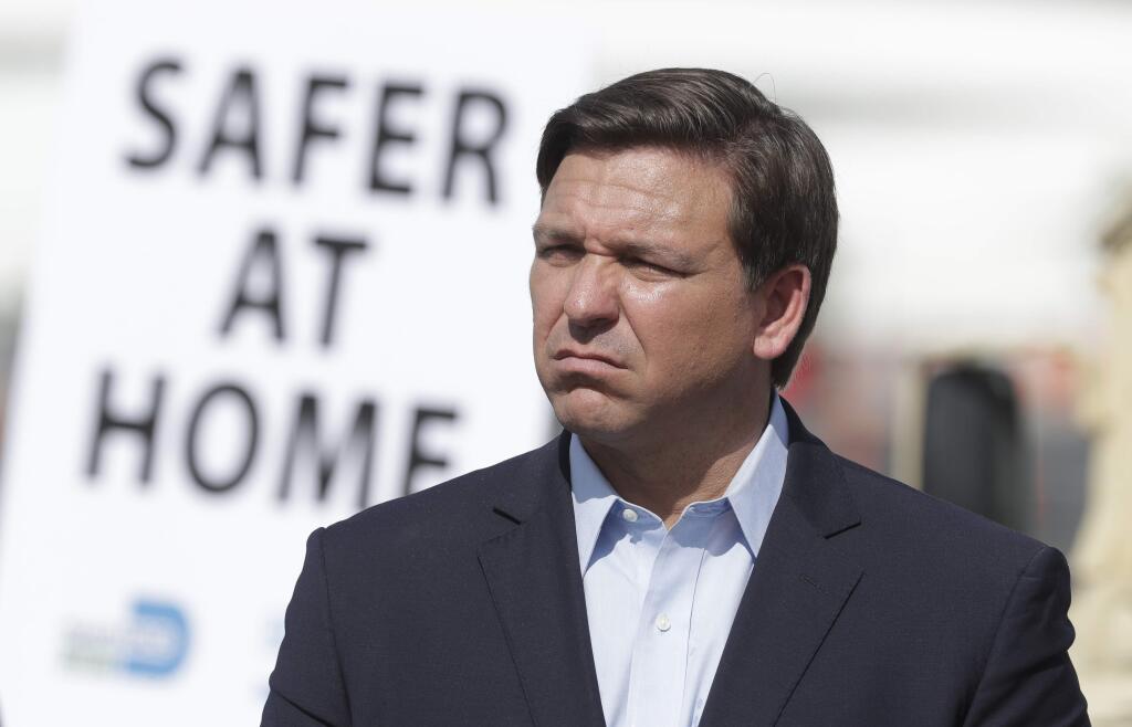 Florida Gov. Ron DeSantis listens during a news conference at a drive-through coronavirus testing site in front of Hard Rock Stadium, Monday, March 30, 2020, in Miami Gardens, Fla. Gov. Ron DeSantis doesn't want the people on the Holland America's Zandaam where four people died and others are sick to be treated in Florida, saying the state doesn't have the capacity to treat outsiders as the coronavirus outbreak spreads. (AP Photo/Wilfredo Lee)