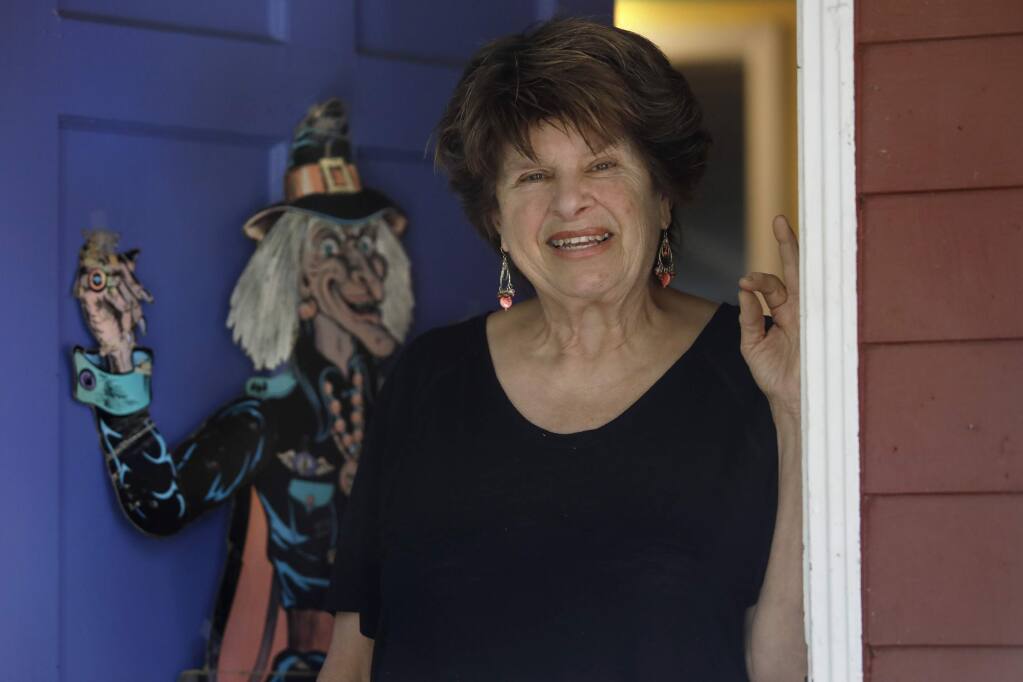 Ellyn Pelikan stands at her front door that is decorated with a paper Halloween witch from 1963 on Thursday, October 18, 2018 in Sebastopol, California . (BETH SCHLANKER/The Press Democrat)