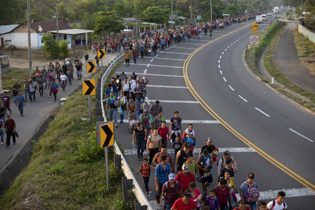 CORRECTS LOCATION - Central American migrants, part of the caravan hoping to reach the U.S. border, walk on the shoulder of a road in Frontera Hidalgo, Mexico, Friday, April 12, 2019. The group pushed past police guarding the bridge and joined a larger group of about 2,000 migrants who are walking toward Tapachula, the latest caravan to enter Mexico. (AP Photo/Isabel Mateos)