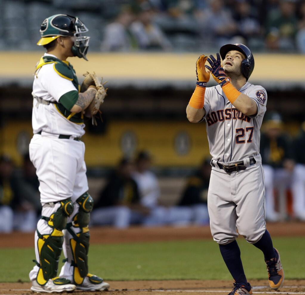 Houston Astros' Jose Altuve, right, celebrates in front Oakland Athletics catcher Bruce Maxwell after hitting a two-run home run off A's Jharel Cotton in the first inning of a baseball game Friday, Sept. 8, 2017, in Oakland, Calif. (AP Photo/Ben Margot)