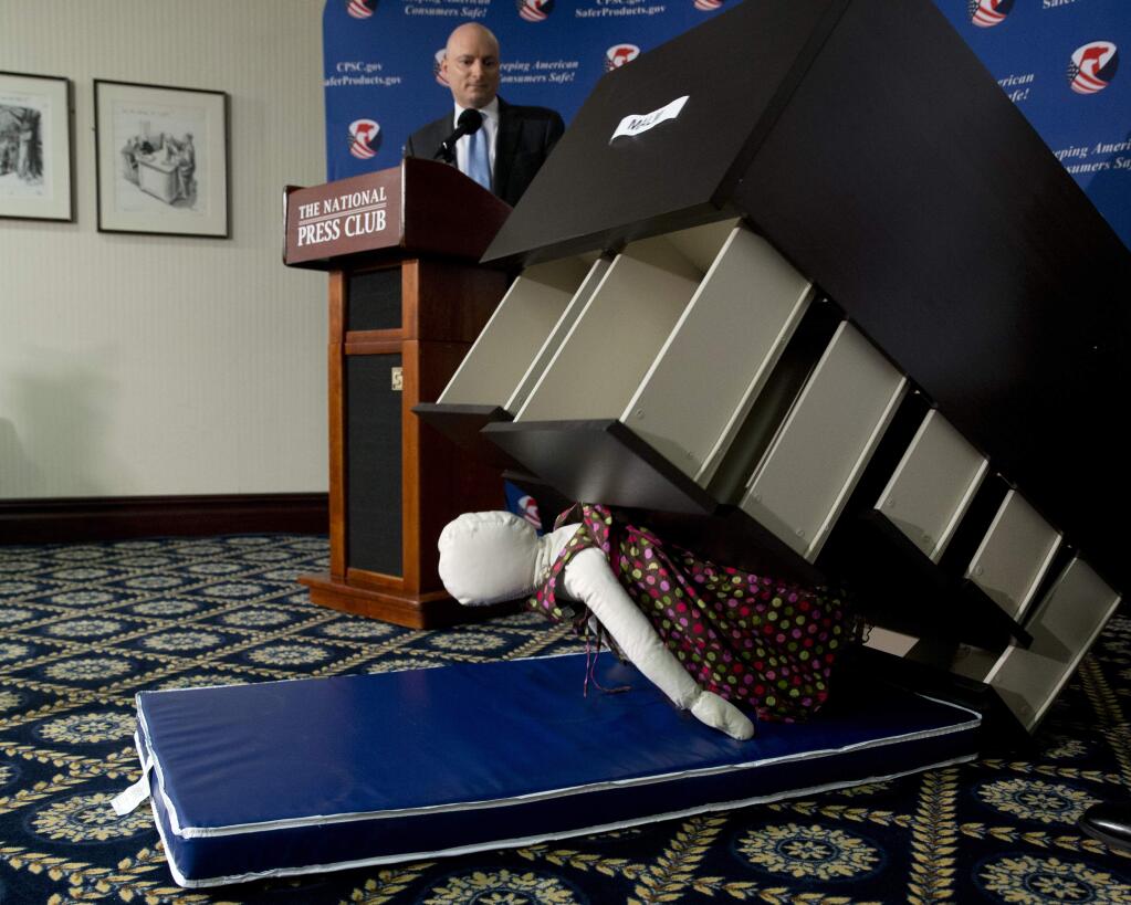Consumer Product Safety Commission (CPSC) Chairman Elliot Kaye watches a demonstration of how an Ikea dresser can tip and fall on a child during a news conference at the National Press Club in Washington, Tuesday, June 28, 2016. Ikea is recalling 29 million chests and dressers after six children were killed when the furniture toppled over and fell on them. (AP Photo/Carolyn Kaster)