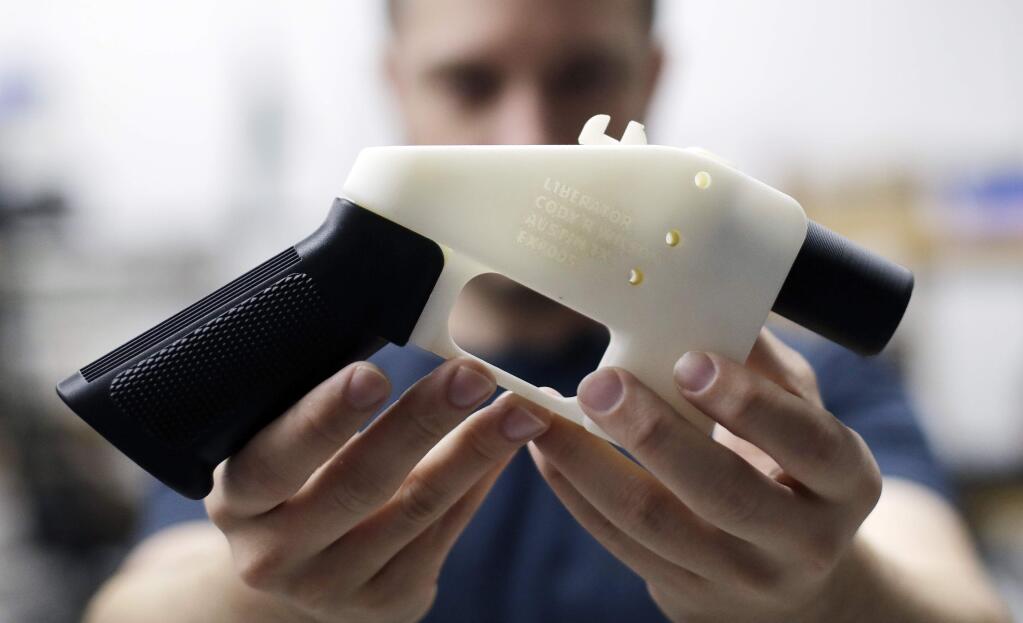 Cody Wilson, with Defense Distributed, holds a 3D-printed gun in his shop in Austin, Texas. (ERIC GAY / Associated Press)