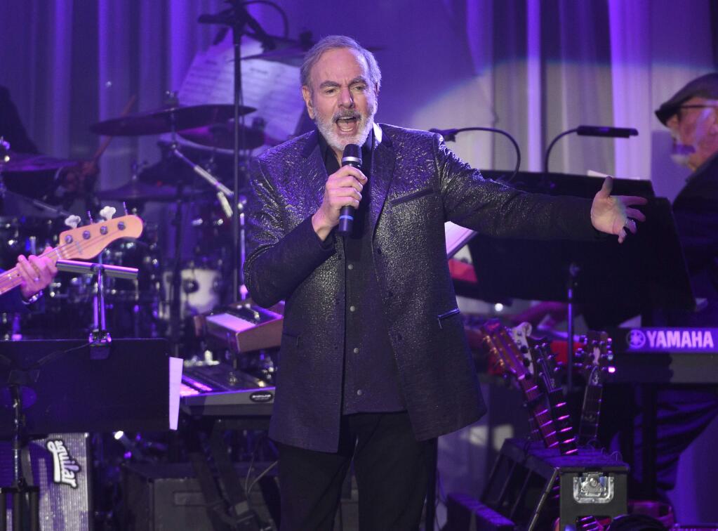 FILE- This Feb. 11, 2017, file photo shows Neil Diamond performing at the Clive Davis and The Recording Academy Pre-Grammy Gala at the Beverly Hilton Hotel in Beverly Hills, Calif. Diamond is retiring from touring after he says he was diagnosed with Parkinson's disease. Diamond turns 77 on Wednesday. Jan. 24, 2018. (Photo by Chris Pizzello/Invision/AP, File)