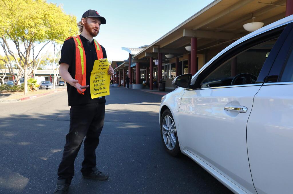 Ian Keiger informs customers about the closure of the Safeway on Calistoga Road because of the power outage and directs them to a different location in Santa Rosa on Wednesday, Oct. 9, 2019. (Christopher Chung/ The Press Democrat)