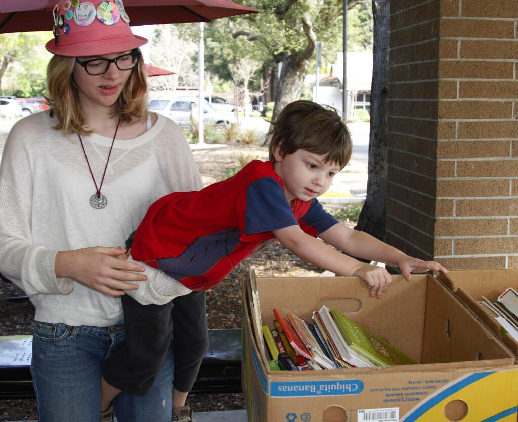 Bill Hoban/Index-TribuneTirteen-year-old Tuesdae Bach tries to pr her 3-year-old brother Hawkeye away from the books Saturday at the Friends of the Sonoma Valley Library book sale. By Saturday, only a small portion of the books remained as library patrons scooped up the used books early during the quarterly four-day sale.
