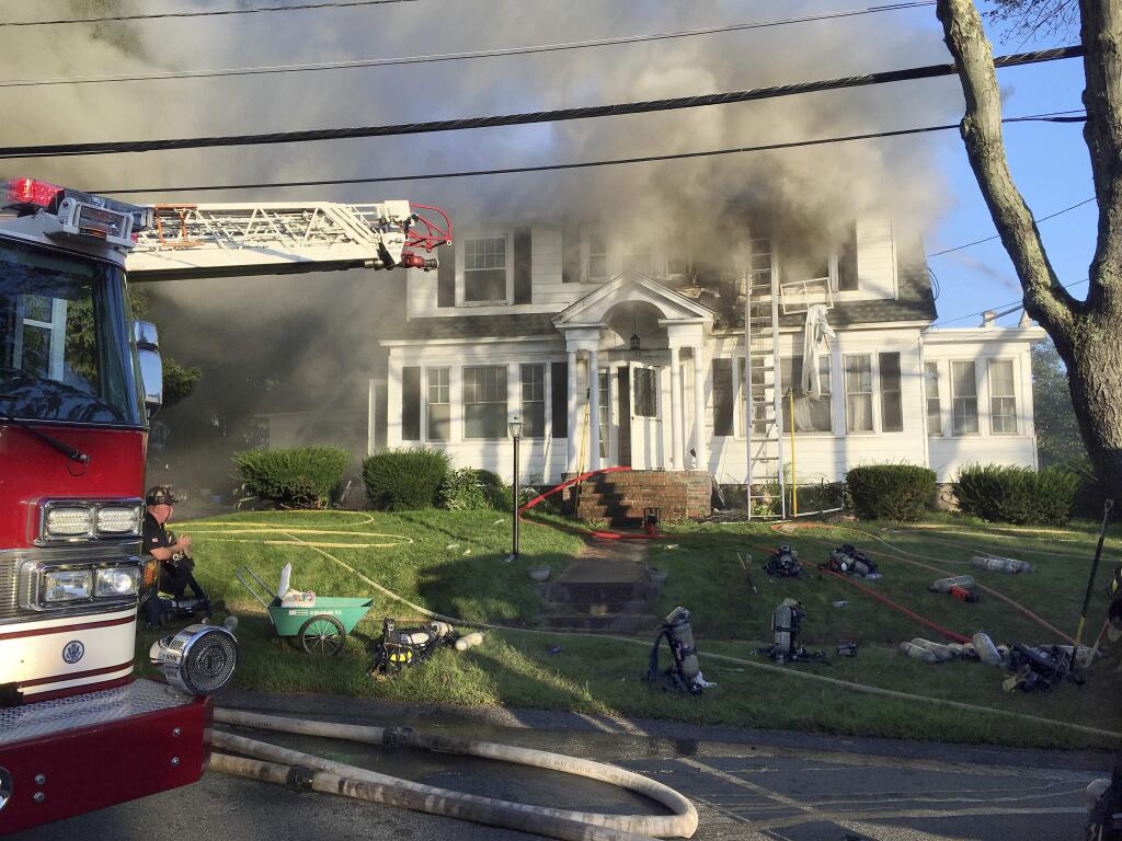 Firefighters battle a house fire, Thursday, Sept. 13, 2018, on Herrick Road in North Andover, Mass., one of multiple emergency crews responding to a series of gas explosions and fires triggered by a problem with a gas line that feeds homes in several communities north of Boston. (AP Photo/Mary Schwalm)