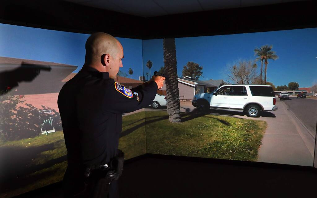 Santa Rosa police officers train on their new use-of-force simulator at their training facility. The video system responds to laser handguns and assault rifles. (John Burgess/The Press Democrat)