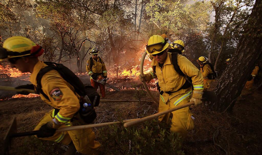 A Cal Fire crew flees a flare up on the Rocky fire near Lower Lake as they try to cut line around the perimeter of the fire on Wednesday, July 29, 2015. (KENT PORTER/ PD)