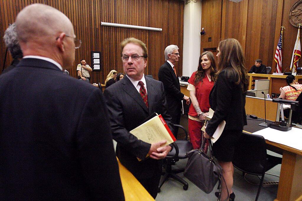 Alix Tichelman, in red, acknowledges her parents as she is surrounded by lawyers on Tuesday, May 19, 2015, in Santa Cruz, Calif. Tichelman, a prostitute charged with killing a Google executive with an overdose of heroin aboard his yacht in 2013, pleaded guilty Tuesday to involuntary manslaughter and administering drugs. The judge sentenced her to six years in prison. (Dan Coyro/Santa Cruz Sentinel via AP)