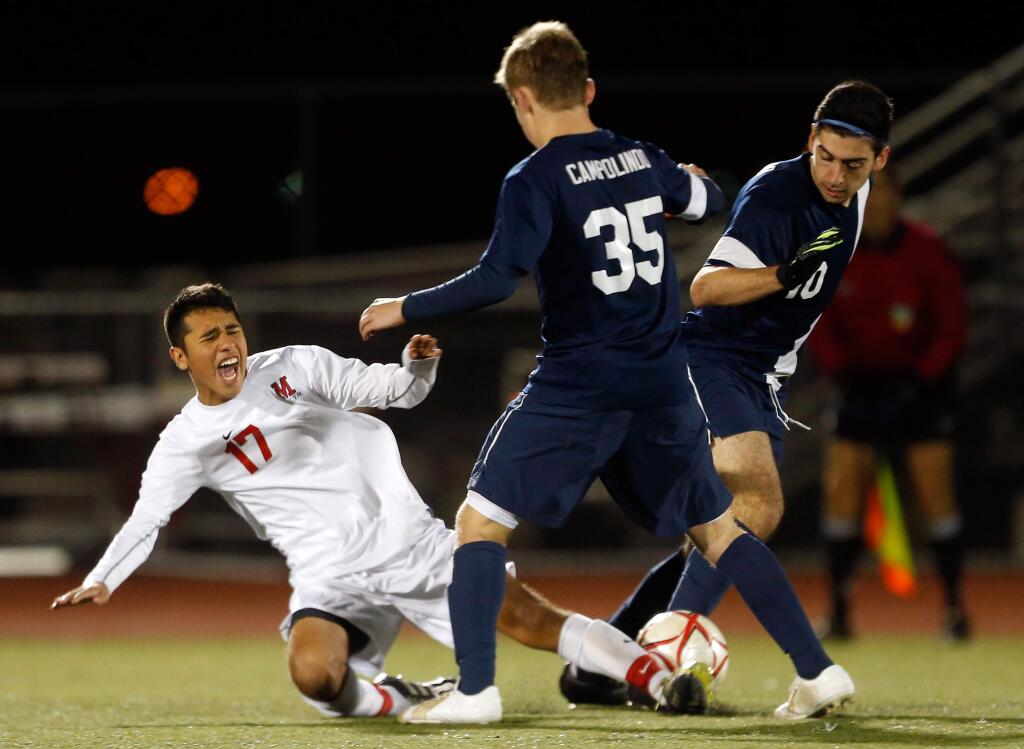 Montgomery's Daniel Guerrero (17) reacts as he falls due to being fouled by Campolindo's Amir Aliakbari (10) during the second half of NCS Division 2 boys soccer quarterfinal match between Campolindo and Montgomery high schools in Santa Rosa, California, on Saturday, February 20, 2016. (Alvin Jornada / The Press Democrat)