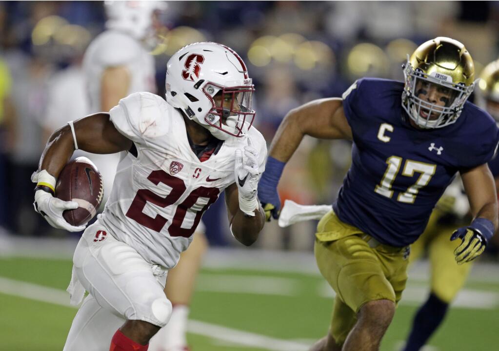 Stanford running back Bryce Love (20) runs around Notre Dame linebacker James Onwualu (17) during the second quarter of a game in South Bend, Ind., Saturday, Oct. 15, 2016. (AP Photo/Michael Conroy)