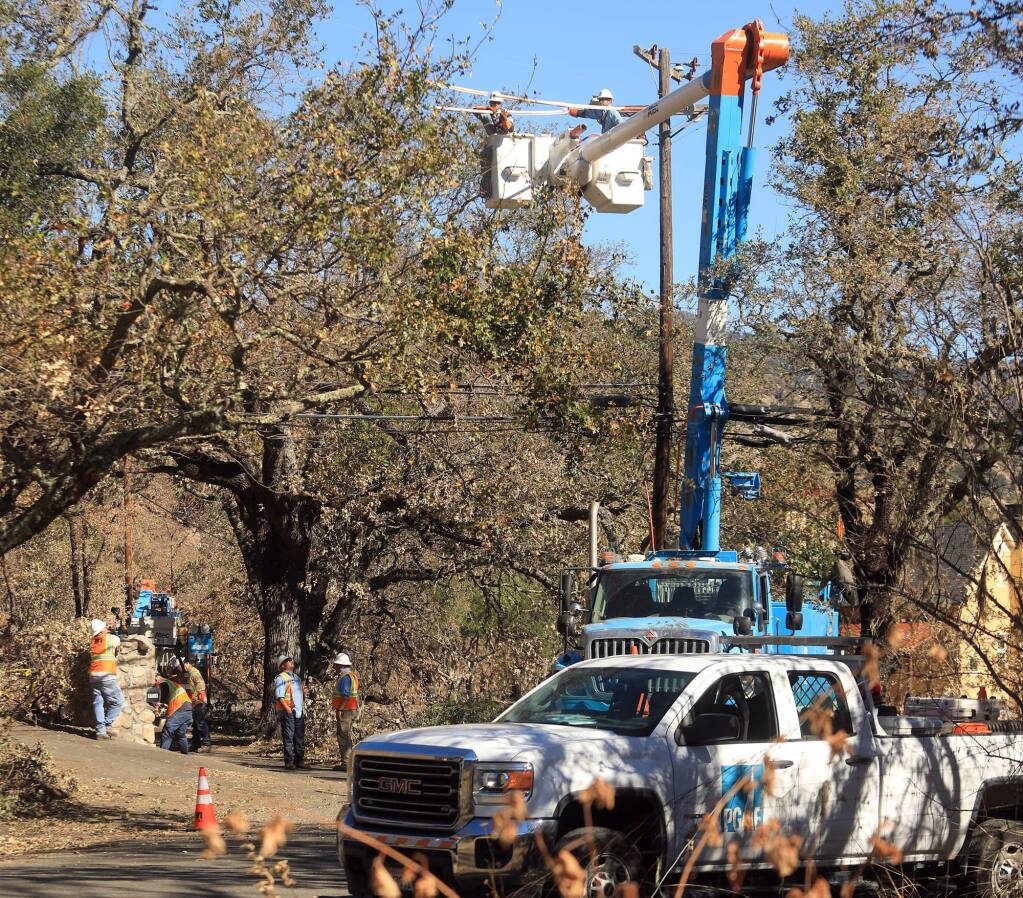 PG&E workers prepare to replace a power pole near the suspected origin of the Tubbs fire on Bennett Lane north of Calistoga, Tuesday Oct. 24, 2017. (Kent Porter / Press Democrat) 2017
