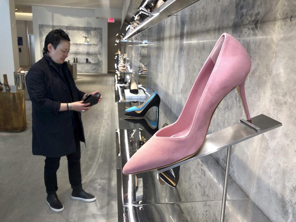 In this June 12, 2019, photo, personal shopper and stylist Kat Yeh looks at shoes for a client in San Francisco. One of the fastest-growing job categories of the past decade has been in what economists call “wealth work”: Catering to the whims, desires and appetites of the wealthy. (AP Photo/Haven Daley)