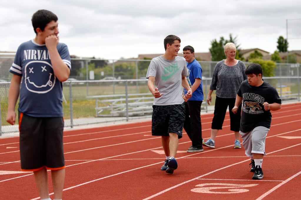 Spencer Rivara, center, gets students on their starting lines before a run during a special needs running club meet at Windsor High School, in Windsor, California, on Tuesday, May 16, 2017. Rivara, who has been diagnosed with autism spectrum disorder and runs on Windsor's varsity track team, started a running group for special education students to pass along the positive benefits of running. (Alvin Jornada / The Press Democrat)