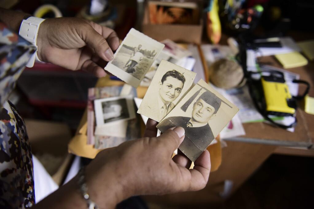 Nerybelle Perez holds several pictures of her father, World War II veteran Efrain Perez, who died inside an ambulance after being turned away from the largest public hospital when it had no electricity or water, days after Hurricane Maria passed, in Guaynabo, Puerto Rico, Thursday, June 7, 2018. The Puerto Rican government says it believes more than 64 died as a result of the storm but it will not raise its official toll until George Washington University completes a study of the same data being carried out on behalf of the U.S. territory. (AP Photo/Carlos Giusti)