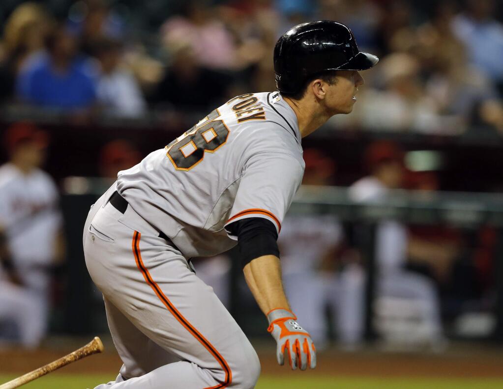 San Francisco Giants catcher Buster Posey hits an RBI single in the eighth inning during a baseball game against the Arizona Diamondbacks, Monday, Sept. 15, 2014, in Phoenix. (AP Photo/Rick Scuteri)