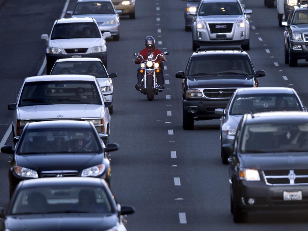 A motorcyclist rides between the lanes during the afternoon commute on southbound Highway 99 in Sacramento. (RANDALL BENTON / Sacramento Bee)