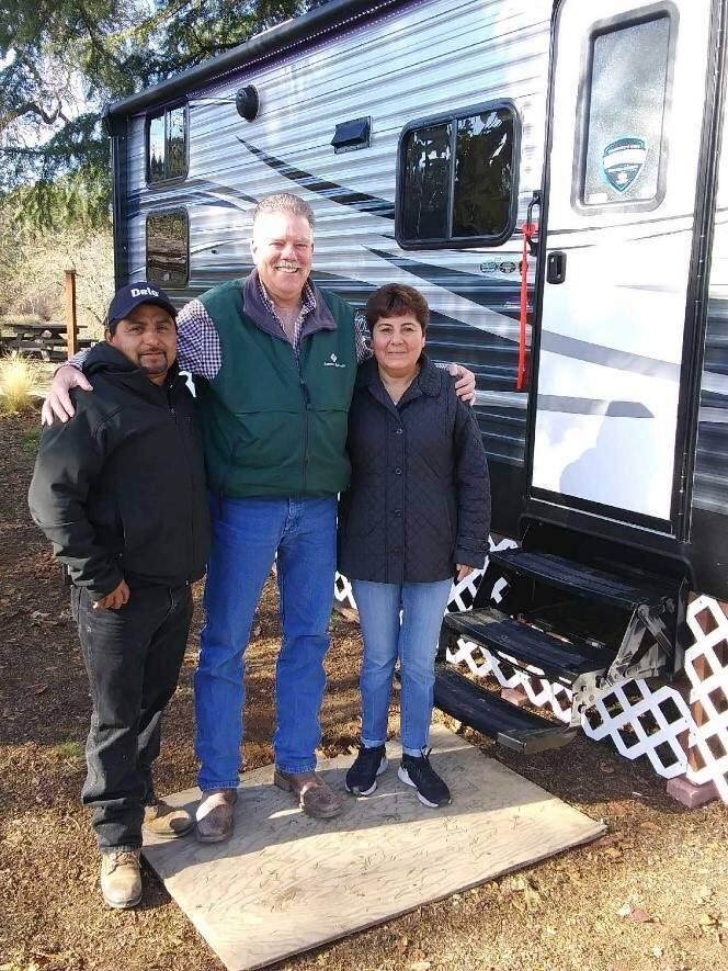 When Emigdio and Celia Olivera lost their home in the fires, they invited employer Kevin Barr (center), partner at Redwood Empire Vineyard Management, to join them in cutting the ribbon on their new RV, provided with funding from the Sonoma County Grape Growers Foundation.