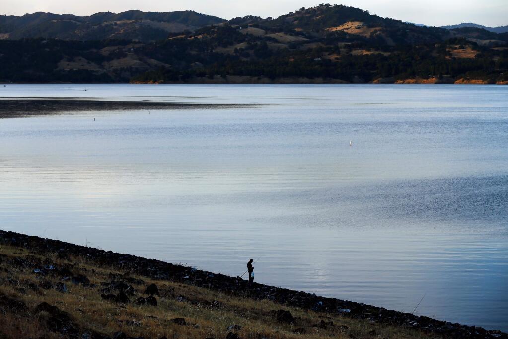A fisherman tends his lines in Lake Mendocino, at the base of Coyote Dam. (ALVIN JORNADA / The Press Democrat)