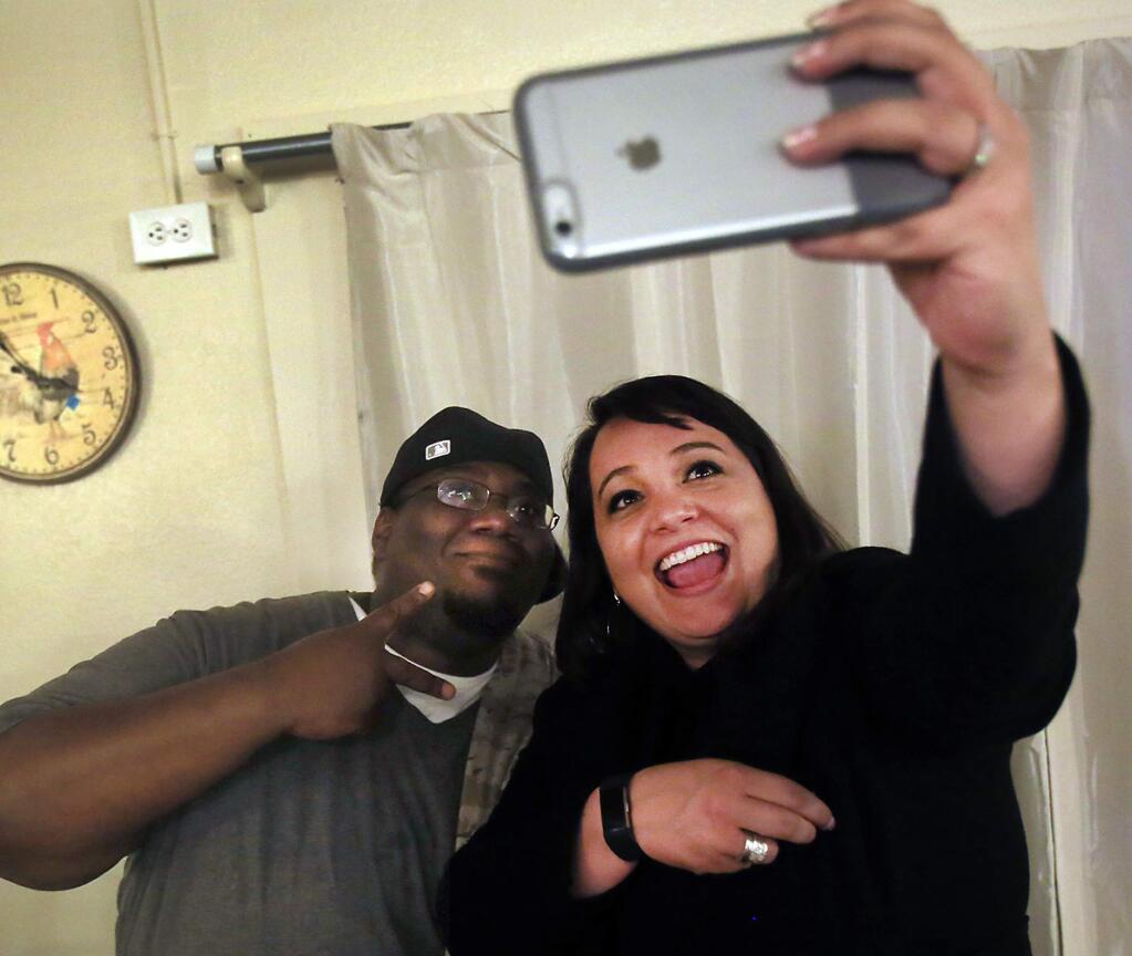 SELFIE STOP: Jennielynn Holmes takes a selfie with Roy during an Easter celebration on Tuesday at the Palms Inn in Santa Rosa. The Palms Inn houses the homeless and came to fruition, in large part, because of Holmes.