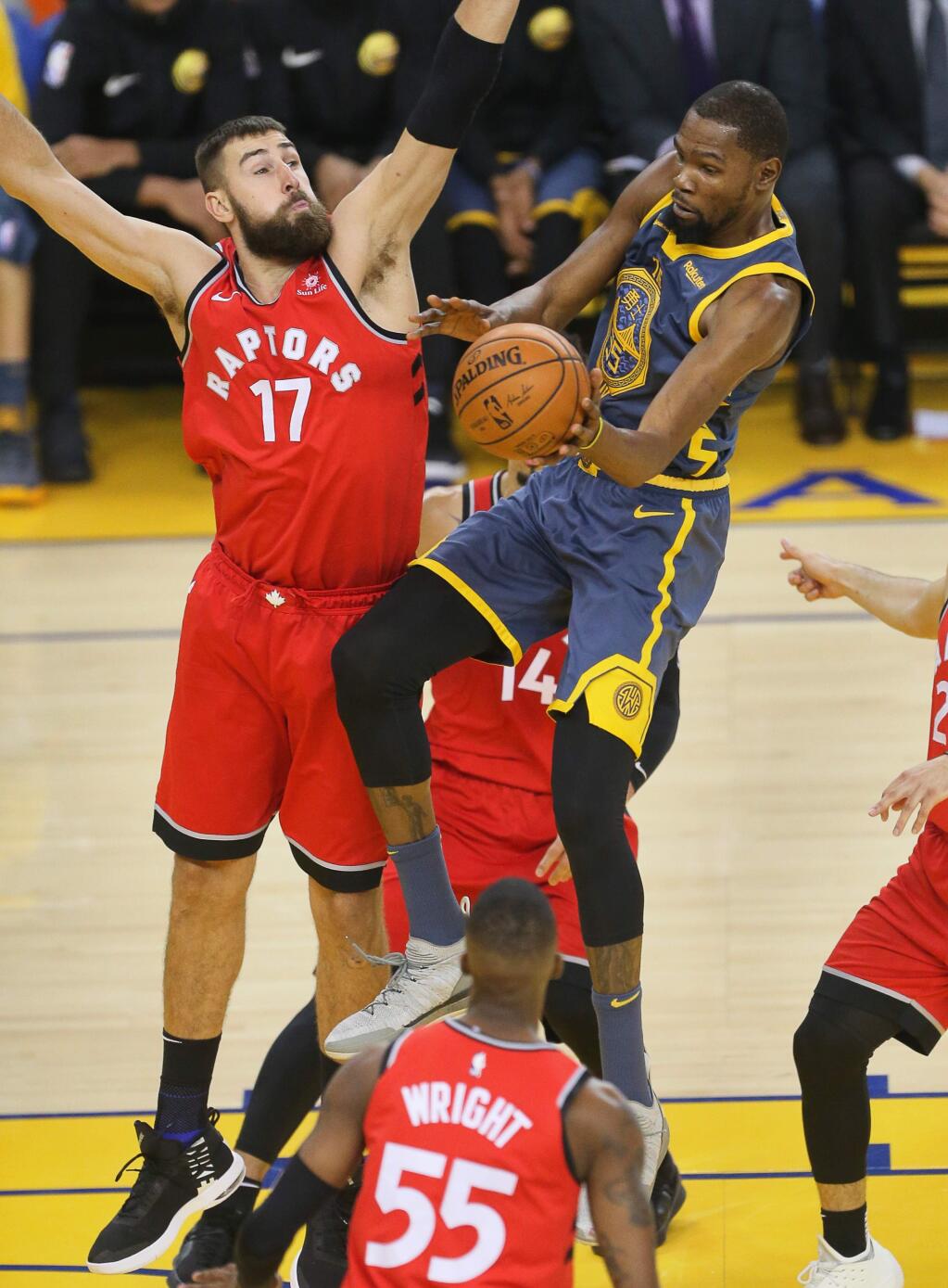 Warriors forward Kevin Durant passes the ball around Raptors center Jonas Valanciunas during their game in Oakland on Wednesday, Dec. 12, 2018. (Christopher Chung / The Press Democrat)