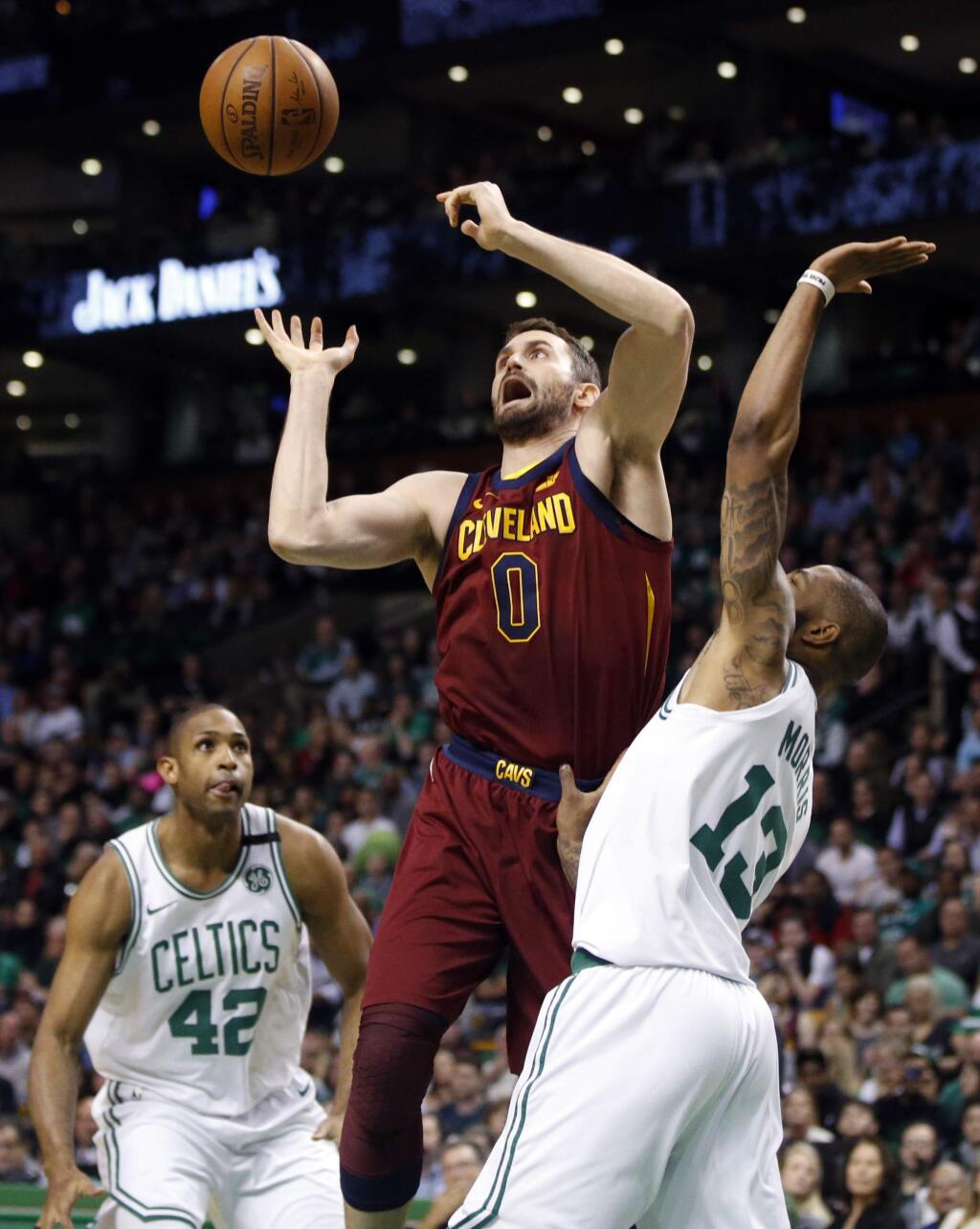 Cleveland Cavaliers center Kevin Love (0) loses control of the ball against the defense of Boston Celtics forwards Al Horford (42) and Marcus Morris (13) during the first quarter of Game 1 of the NBA basketball Eastern Conference Finals, Sunday, May 13, 2018, in Boston. (AP Photo/Michael Dwyer)