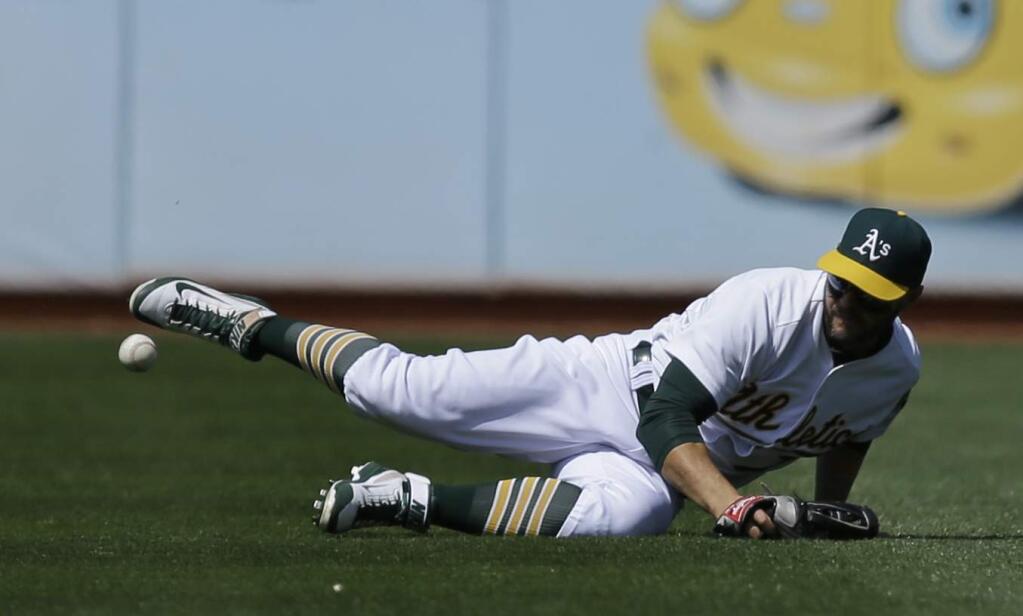Oakland Athletics' Cody Ross drops a ball hit by Houston Astros' Colby Rasmus in the seventh inning of a baseball game Saturday, April 25, 2015, in Oakland, Calif. (AP Photo/Ben Margot)